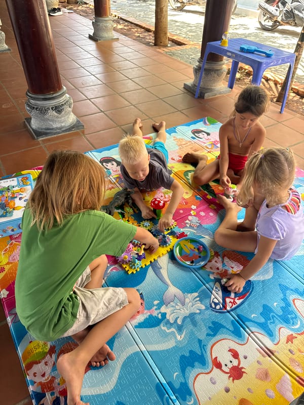Children play with toys on outdoor mats in Mũi Né