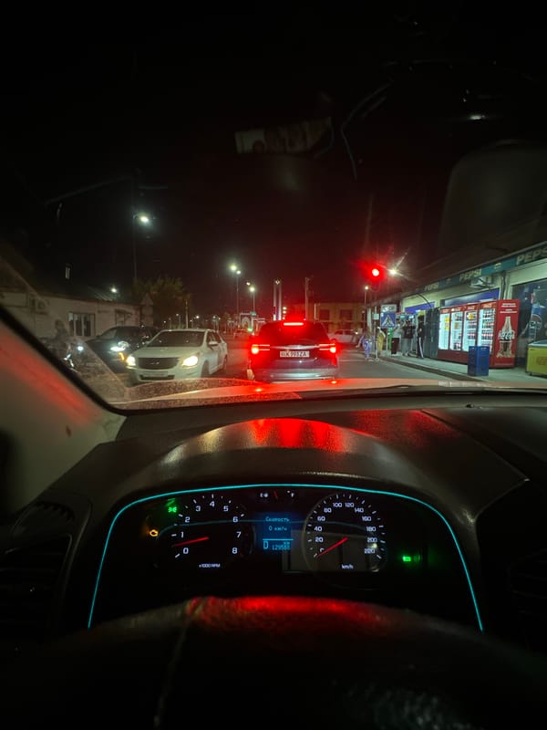 Tashkent night traffic, stopped at a red light near shops