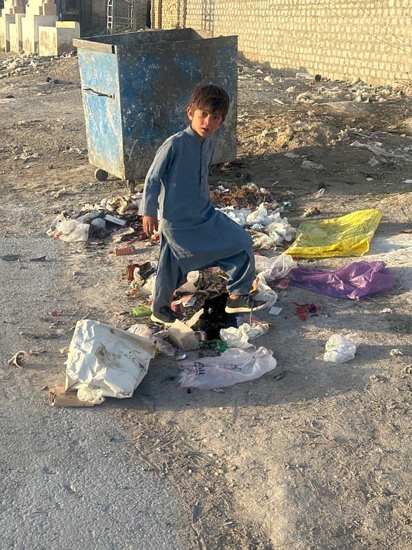 Boy stands amid litter in Quetta City Tehsil