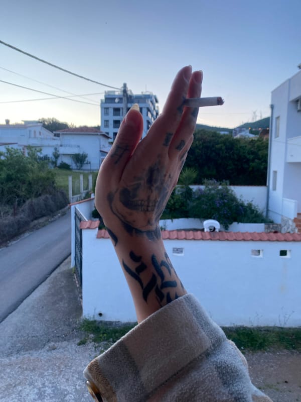 Tattooed person smoking cigarette observed in Kunje, Montenegro