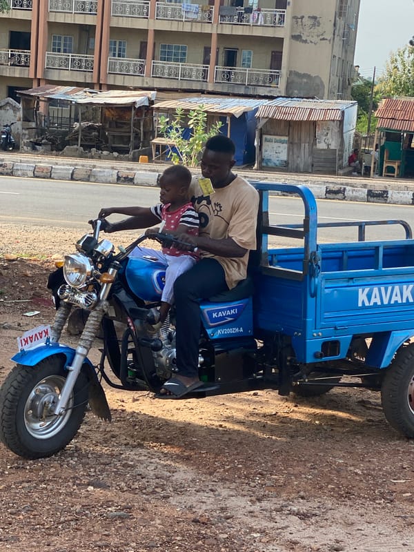 Man, child share motorcycle ride in Nigerian town