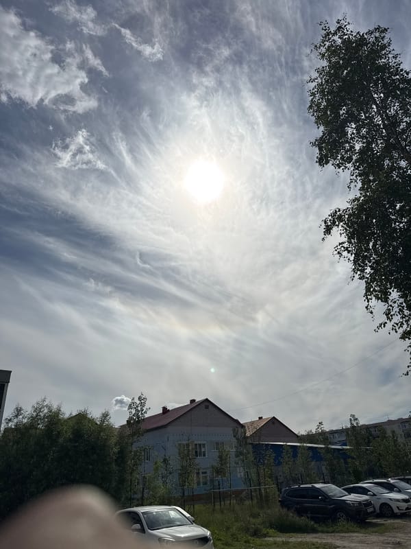 Midday drive through Usinsk under a hazy summer sky