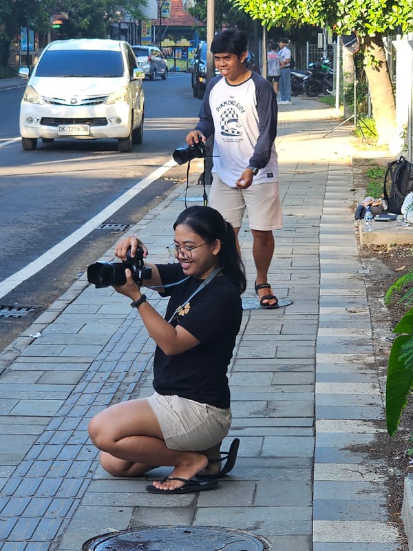Two people photographing on Denpasar sidewalk at night
