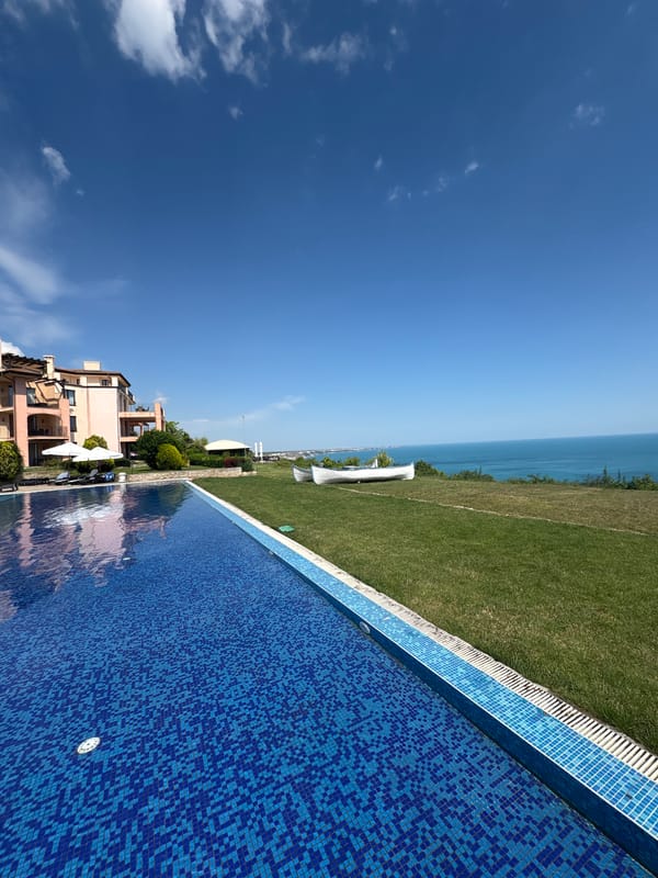 Sunny day at a coastal resort pool with sea views