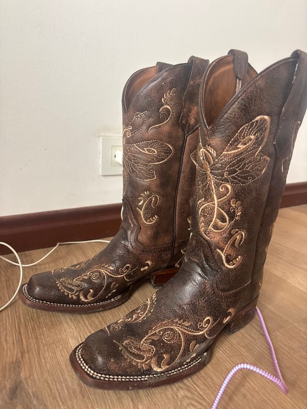 Embroidered cowboy boots spotted on wooden floor in Medellín