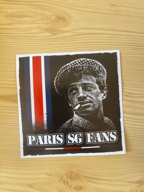 Stickers and a coaster on a wooden surface in Paris