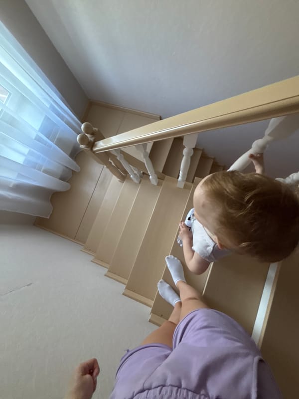 Child plays with toy cars on stairs in Russian home