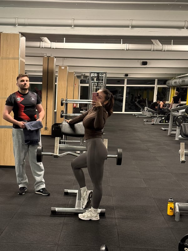 Woman exercises at Mönchengladbach gym, makes peace sign with phone