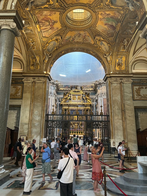 Tourist documents ornate Santa Maria Maggiore basilica interior in Rome