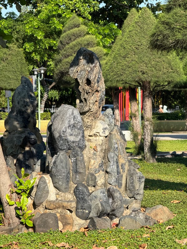 Nha Trang park grounds with rock sculptures and a groundskeeper at work