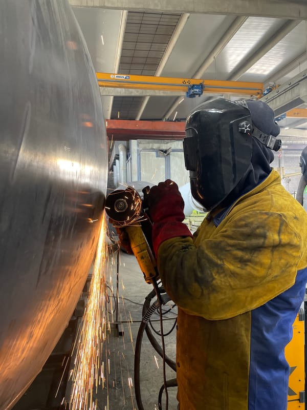 Worker grinds metal surface in Montenegro industrial activity