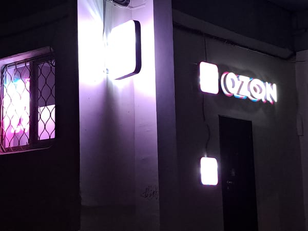 Neon signs light up a building exterior in nighttime Irkutsk