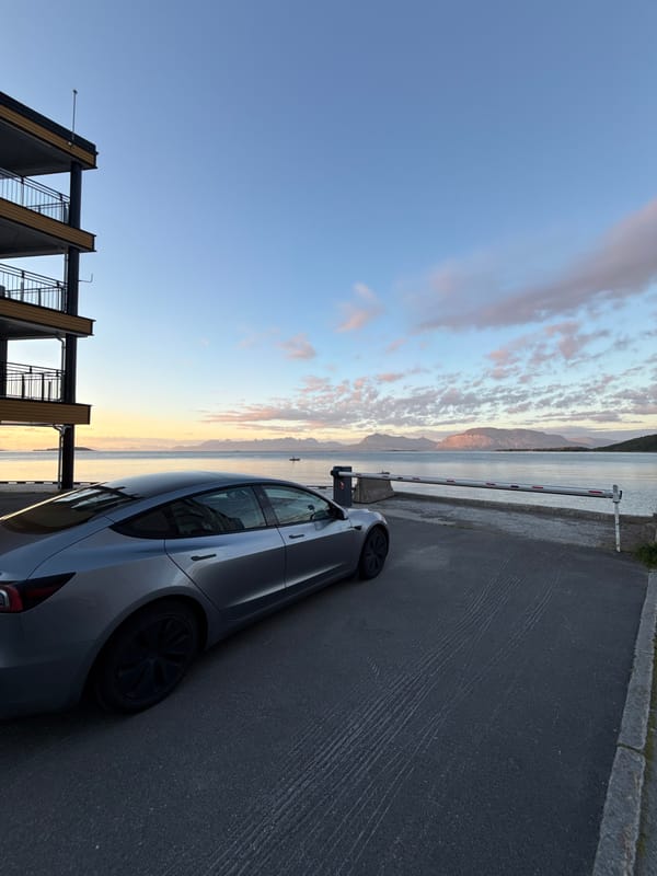 Tesla parked by the fjord in Harstad under a late-evening sky