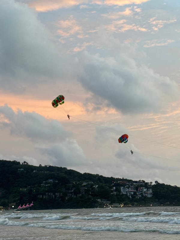 Patong Beach sunset: parasails, waves, and a stormy sky