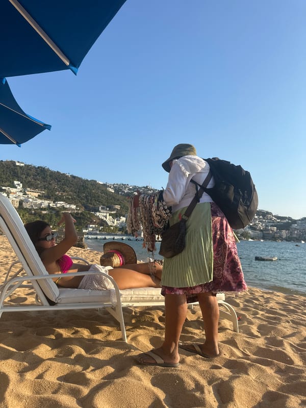 Beachgoers relax under umbrella at Acapulco resort