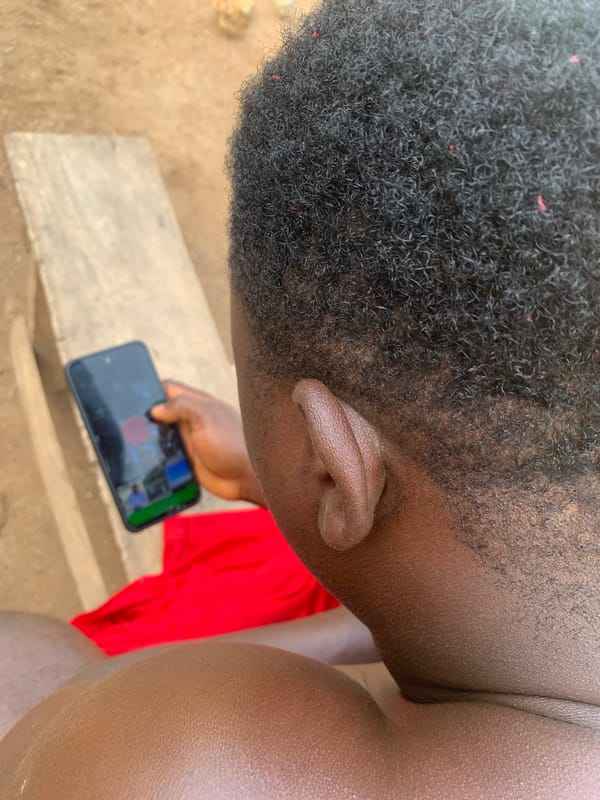 Person uses smartphone on bench in Akwanga, Nigeria