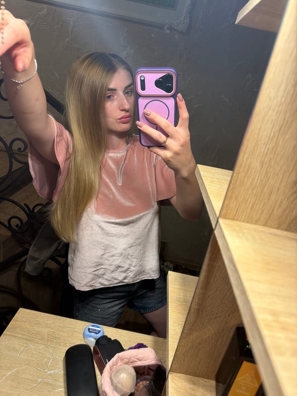 Mirror selfie on a wooden staircase in a pink velvet top