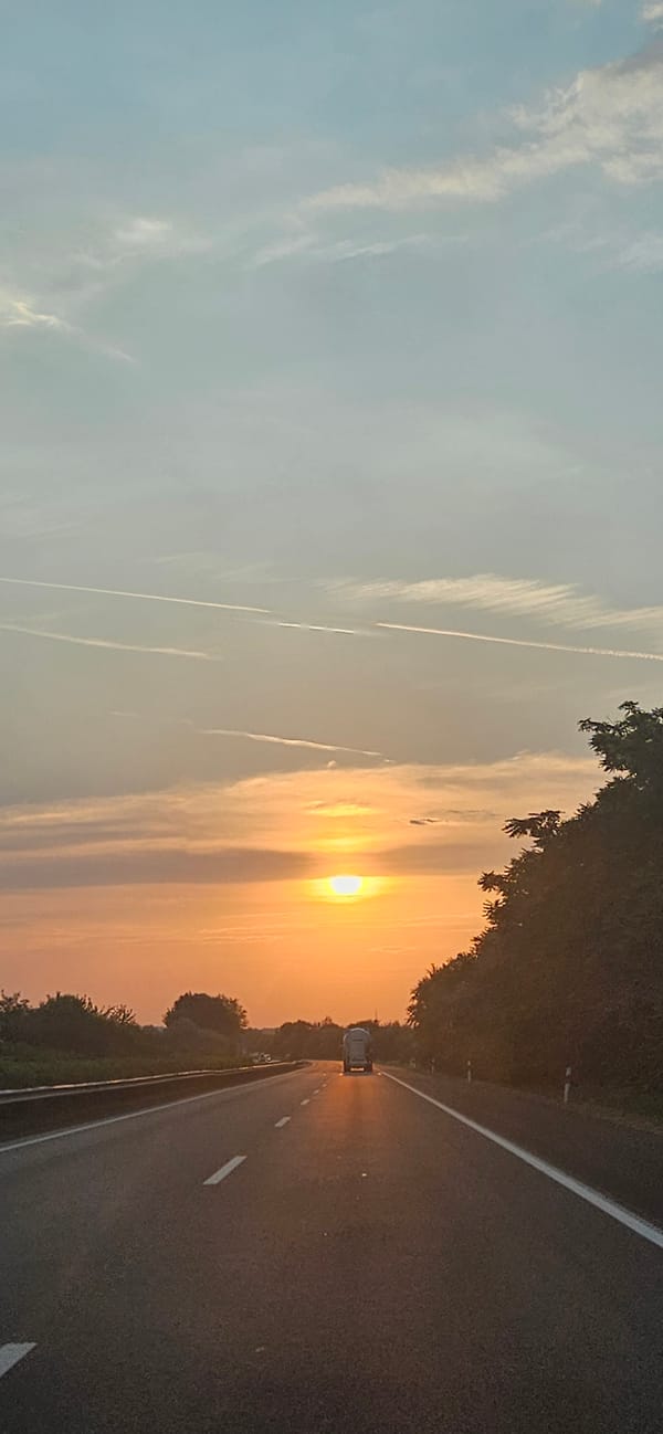Orange sunset fades over a highway in rural Hungary