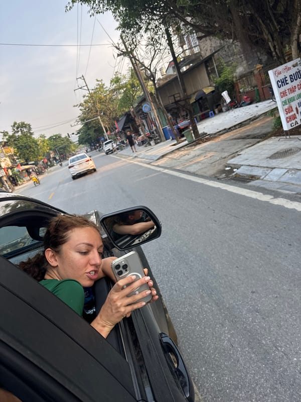 Woman films from car window on Vietnamese street