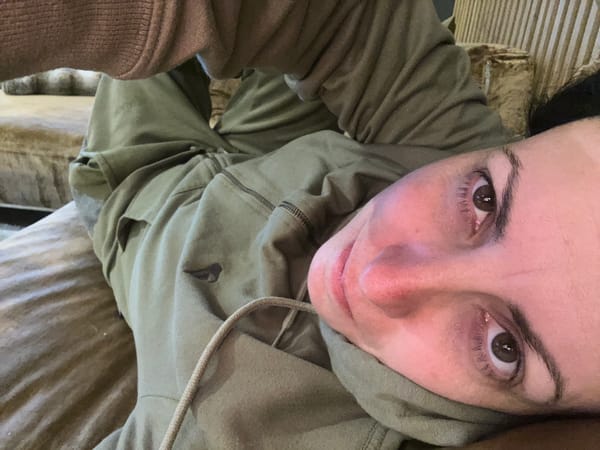 Person captures emotional selfies in green hoodie in Sofia