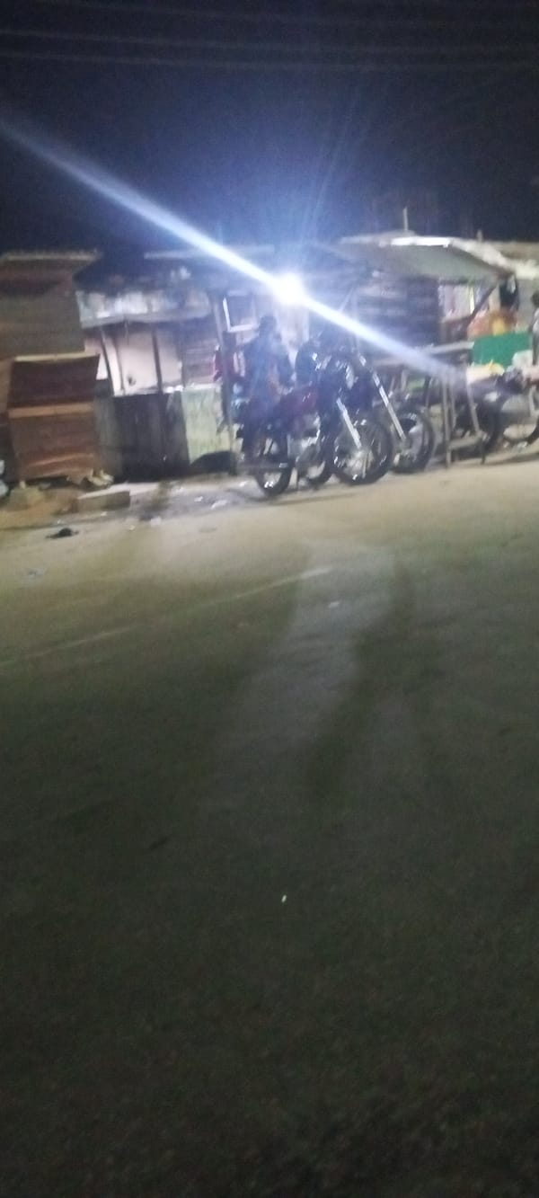 Nighttime street activity with motorcycles and pedestrians captured