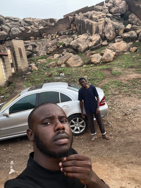 Two men photographed near silver car outdoors