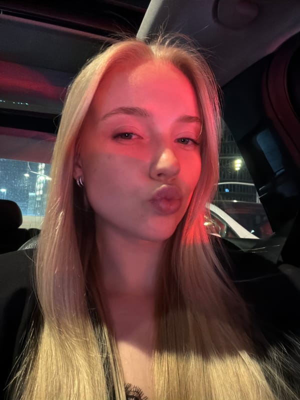 Woman Takes Nighttime Car Selfies With City Lights Backdrop