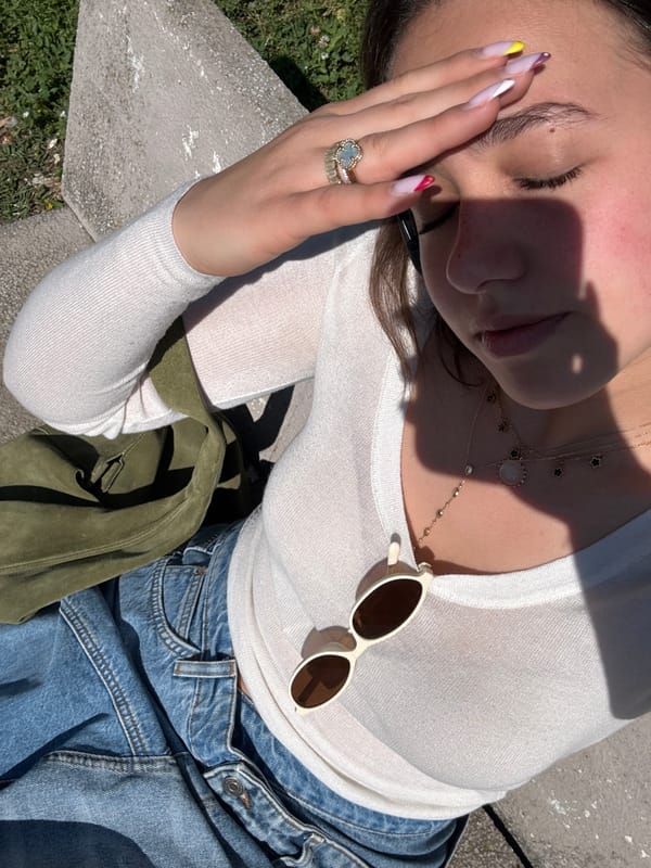 Woman rests in Milan park wearing denim and jewelry