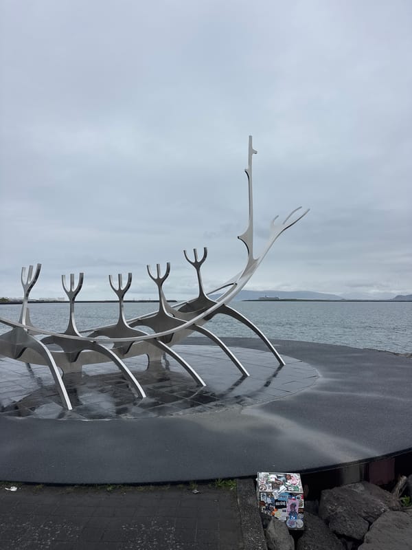 Tourists visit Sun Voyager sculpture in Reykjavik under grey skies