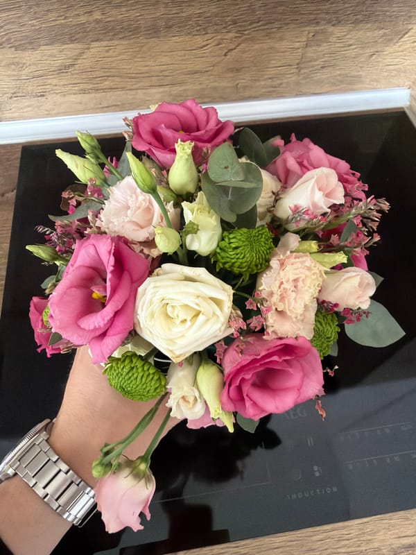 Person holds flower bouquet over kitchen cooktop in Sofia