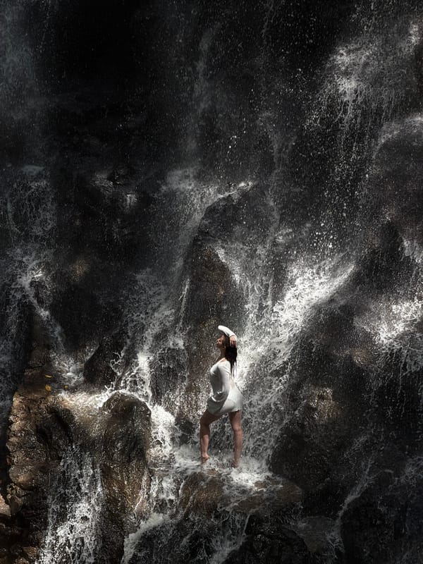 Standing in the spray of a waterfall in Gianyar, Bali