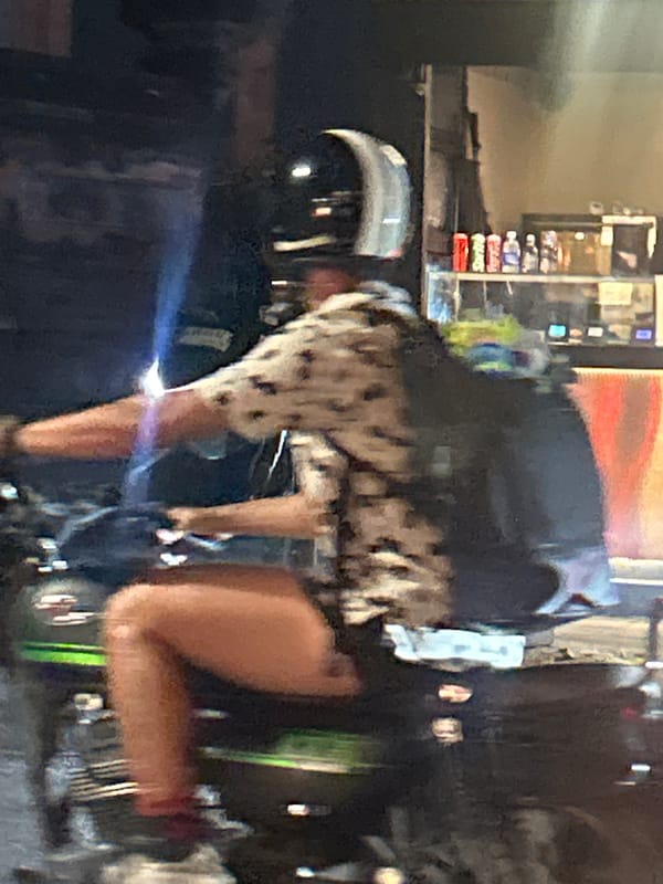 North Kuta street at night, scooters and storefronts in motion