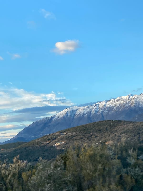 Snow-capped mountains viewed from vehicles in Montenegro countryside