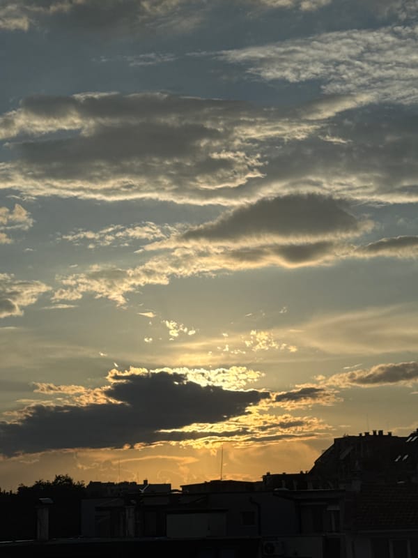 Sunset clouds create golden glow over building