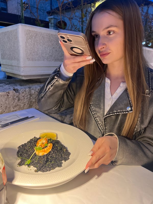 Tourist photographs seafood meal at Perast restaurant