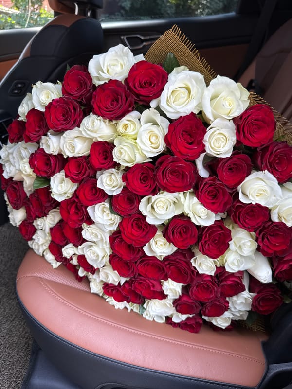 Red and white rose bouquet photographed in a car, Almaty