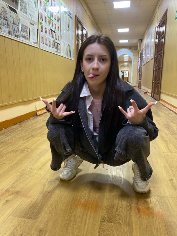 Young woman poses in indoor hallway during photo session