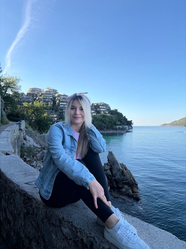 Woman sits by Adriatic Sea in Budva Montenegro