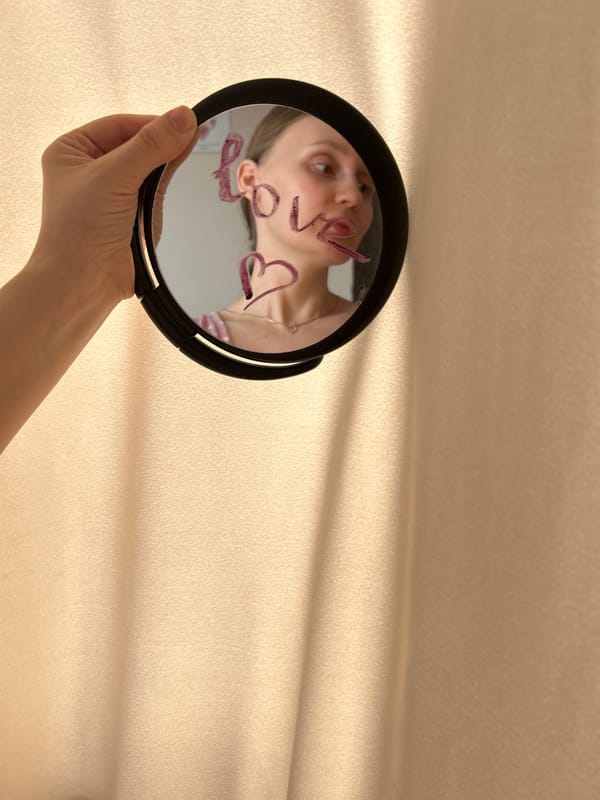 Woman holds mirror with 'love' written in lipstick, Ufa