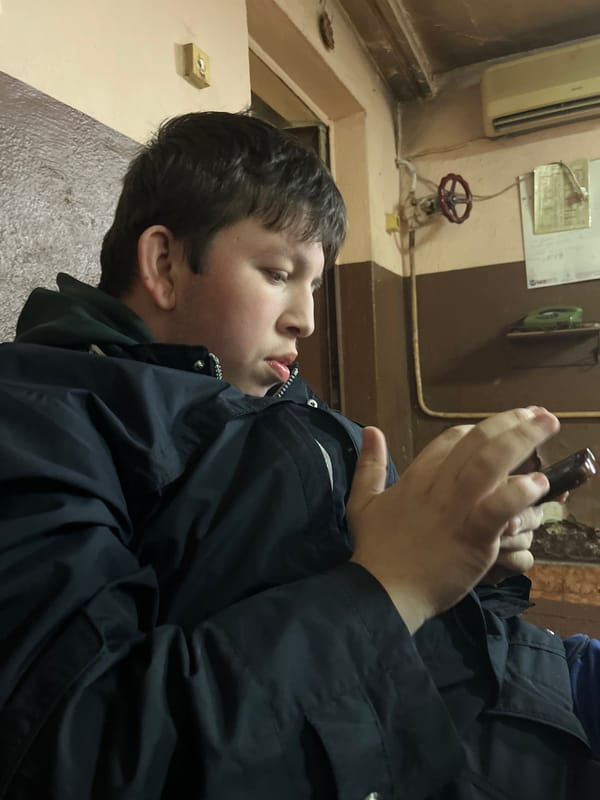 Youth uses handheld device in Sofia communal room