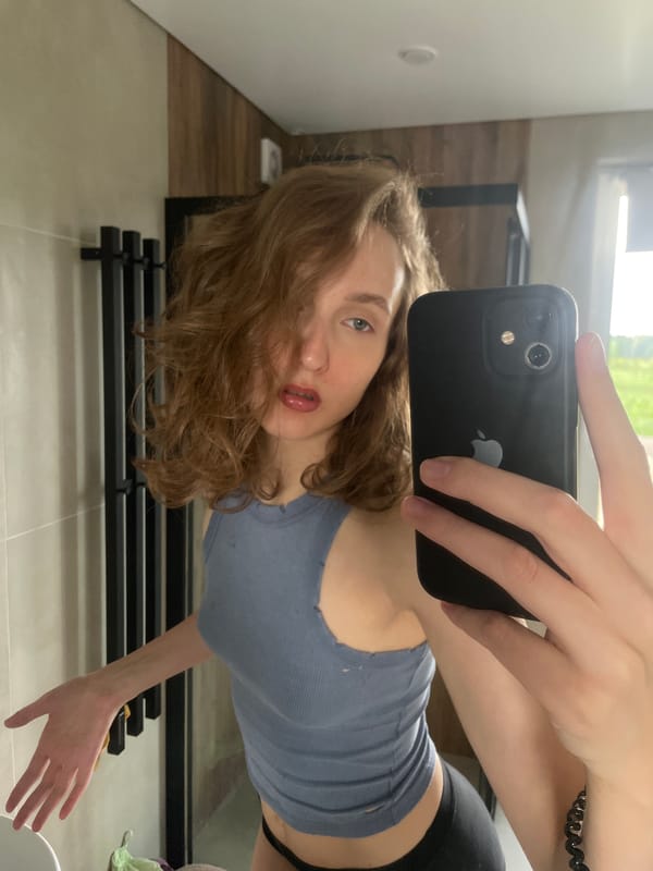 Woman takes selfies, applies makeup in bathroom mirror session