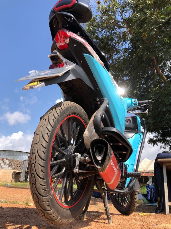 Roadside hang in Jos: food, cash, and a parked bike