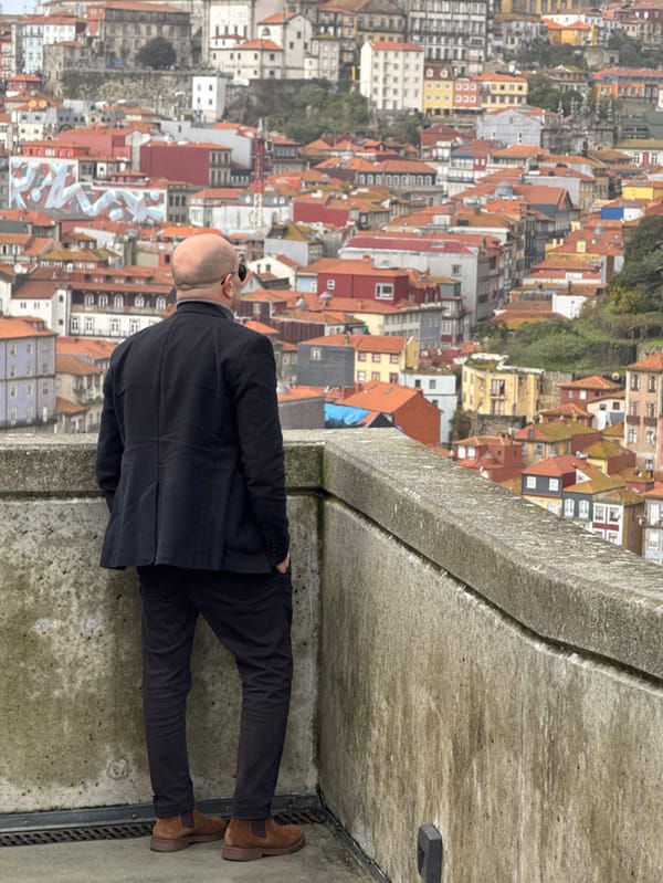 Man views Porto cityscape from Vila Nova de Gaia platform