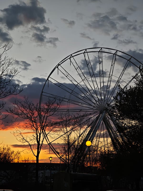 Dramatic sunset illuminates Plovdiv skyline with Ferris wheel silhouette