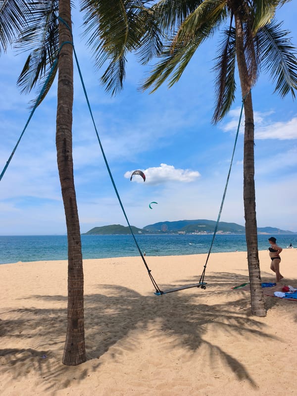 Kitesurfers and beachgoers share a bright Nha Trang morning