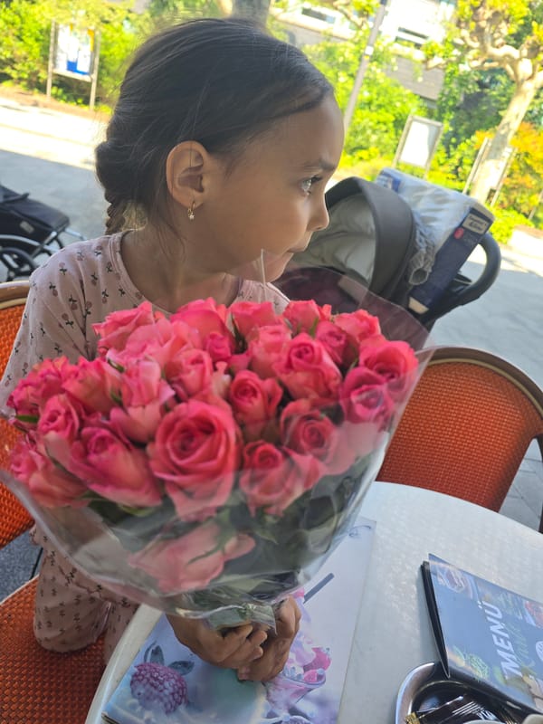 Young girl holds pink roses at cafe