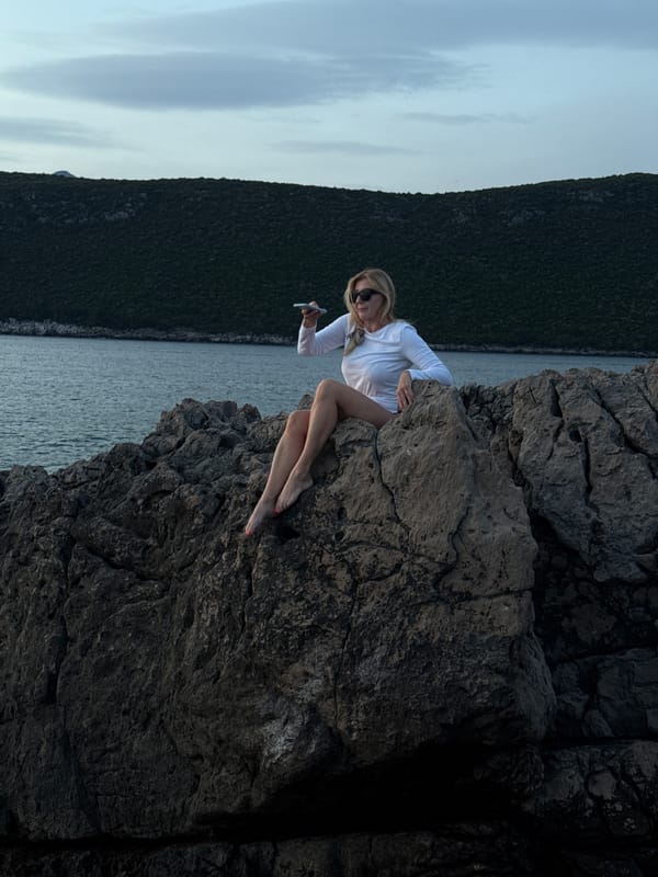 Woman relaxes on Montenegro coast with phone