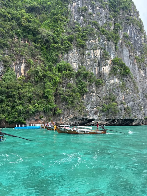 Speedboat and longtail boats navigate Haad Yao's limestone coastline