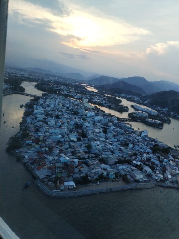 Daytime aerial views document Nha Trang Ward cityscape and bridge