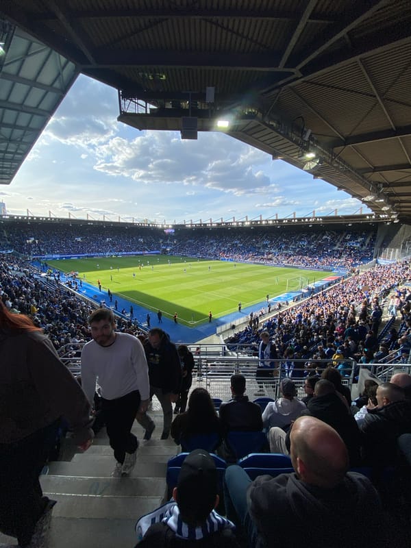 Soccer match underway at Strasbourg stadium with crowds present